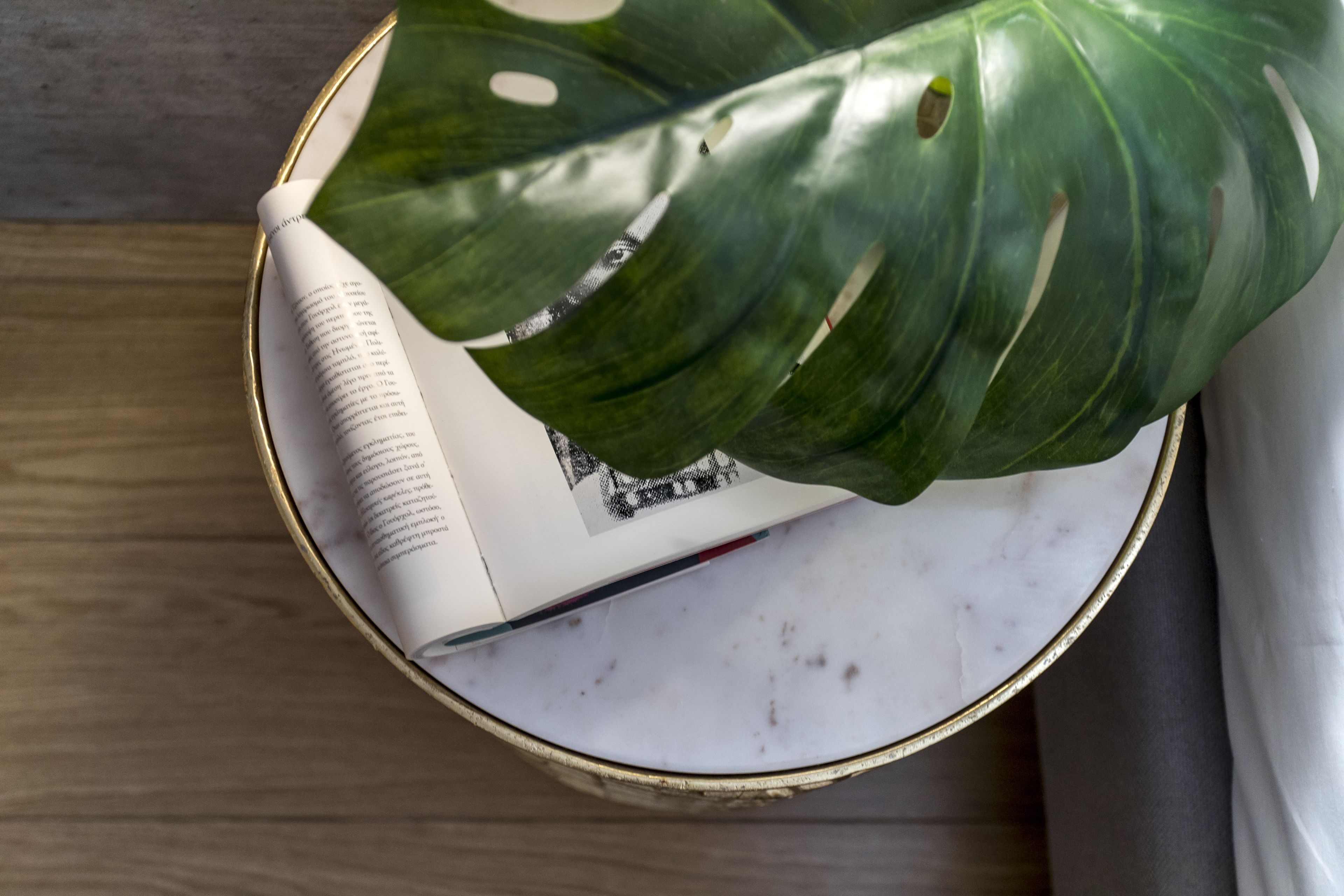 Un livre sur lequel repose une feuille, le tout posé sur une surface en marbre.