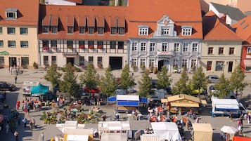 A bustling outdoor market with various stalls and a prominent building with a traditional facade.