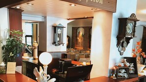 A reception desk with a brick base, wooden counter, and a sign that reads "Reception". - Hotel zum Schwan (Beeskow)