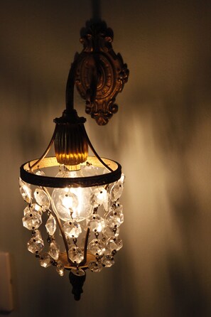 A chandelier with multiple crystal elements and a warm light source. - Juliet's Nest (Verona)