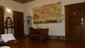 Une pièce avec une grande carte accrochée au mur, un bureau avec une lampe, une chaise et une porte en bois portant l’inscription « 1 ».