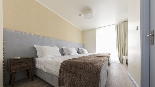 A hotel room with a large bed, a bedside table, and a small bedside table. - D' El Rei B&B (Matosinhos)