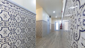 A hallway with patterned tile walls and wooden flooring. - D' El Rei B&B (Matosinhos)