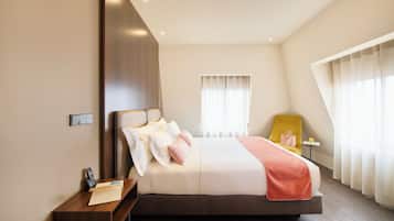 Una habitación de hotel moderna con una cama grande, una mesita de noche y una silla.