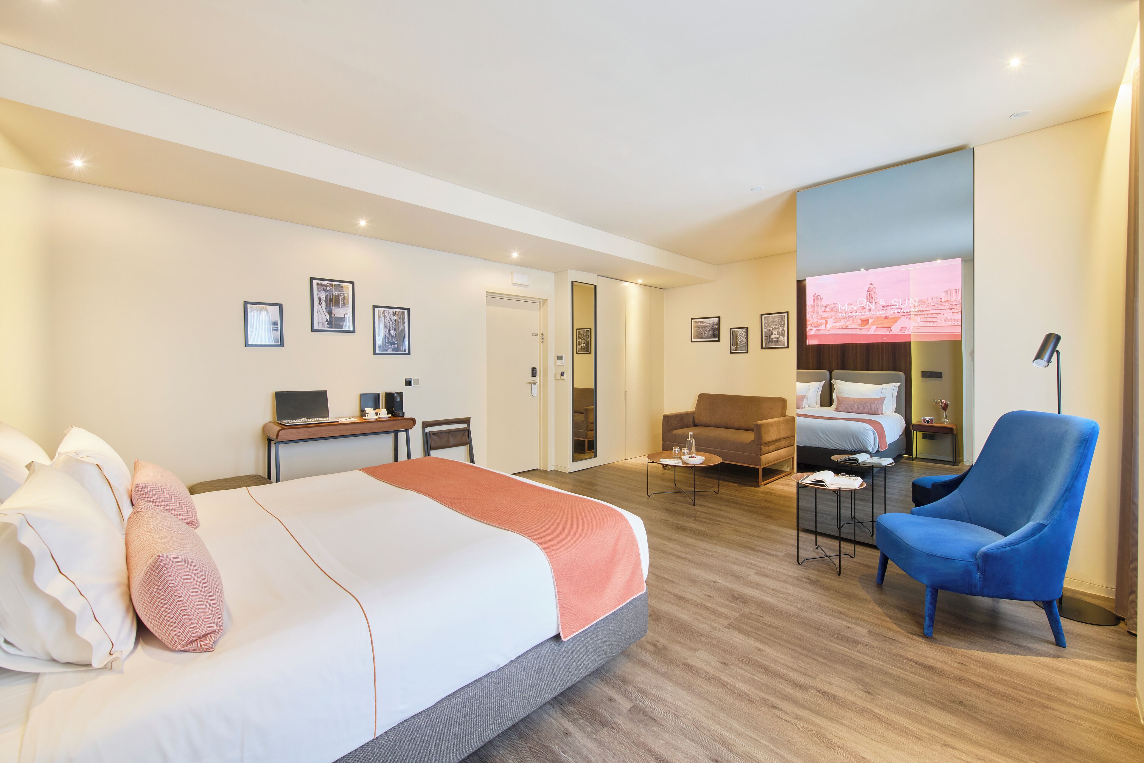 Habitación de hotel con una cama grande, un escritorio, una silla, un televisor y un sofá.