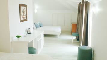 Una habitación con cama, escritorio, silla y un pequeño reposapiés.