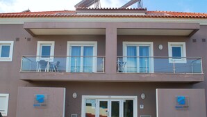 A building with a balcony, a door marked with the number 109, and two signs with the logo 'Baleal Spot'. - Hotel Baleal Spot (Peniche)