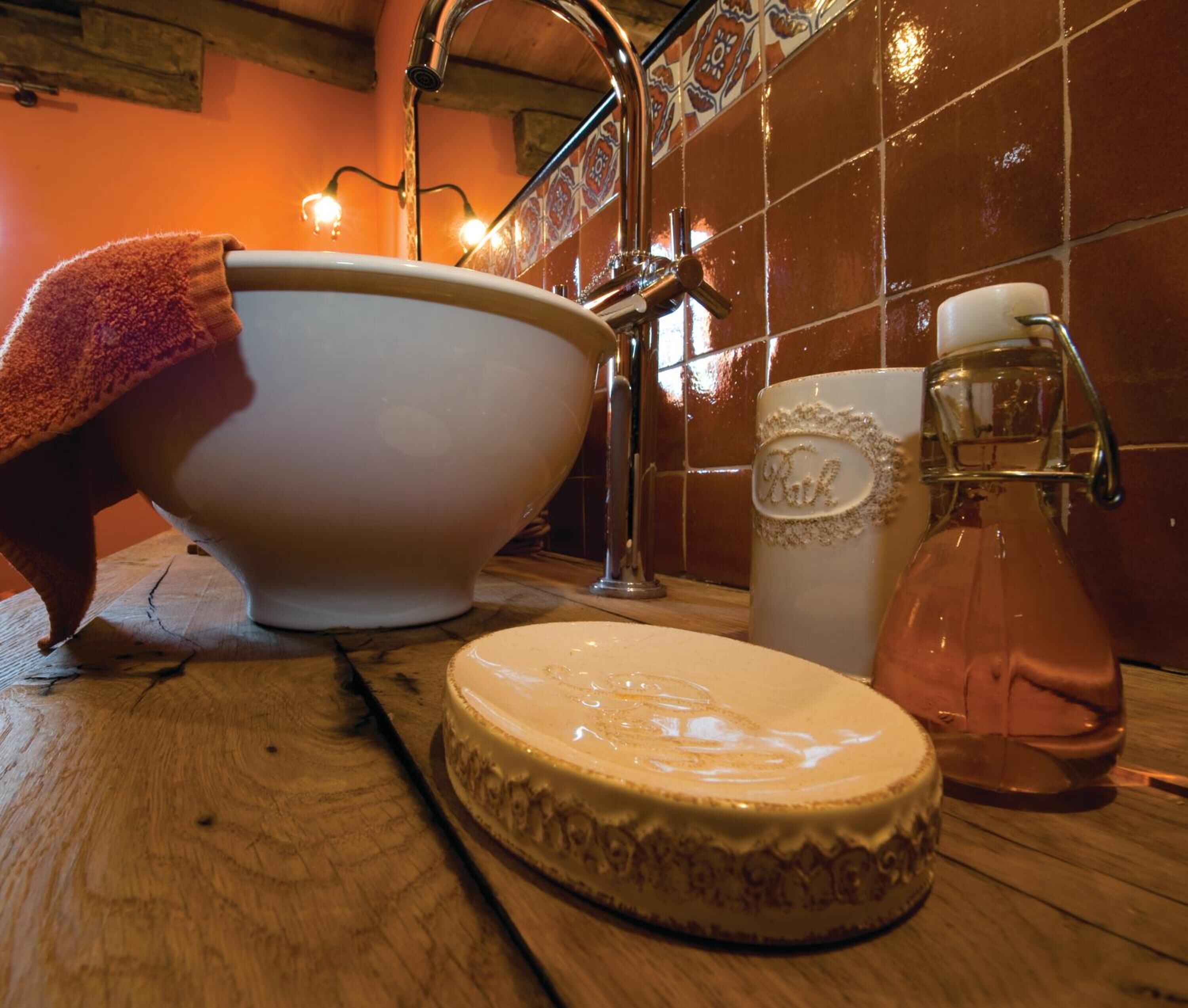 Un plan de travail de cuisine avec un saladier, une carafe et une assiette décorative.