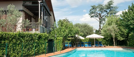 Een seizoensgebonden buitenzwembad, parasols voor strand/zwembad