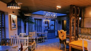 A dining area with wooden furniture, a lion chair, and a large window with blinds. - The Queens at Horton (Telford)