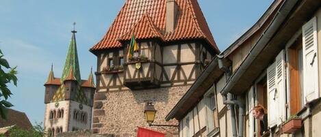 Ein historisches Gebäude mit einem Ziegeldach und einem Steinturm.