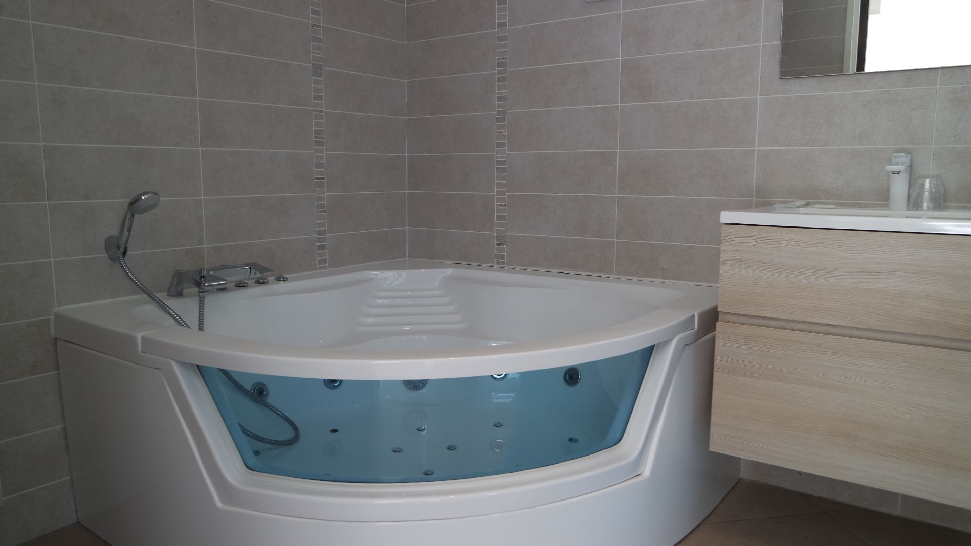 Un baño moderno con una bañera independiente, ducha integrada y tocador de madera.