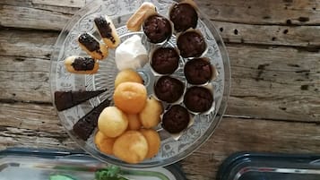 A glass plate with various pastries and desserts on a wooden surface.