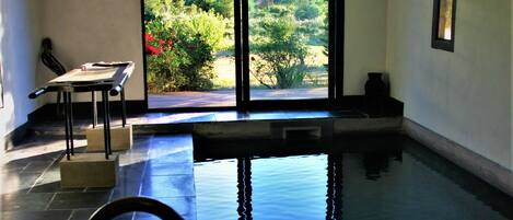 Alberca techada, alberca al aire libre y sombrillas en la alberca