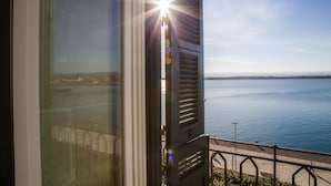 A view from a window overlooking a body of water with a distant shoreline and a clear sky. - Dimora di Ulisse (Syracuse)