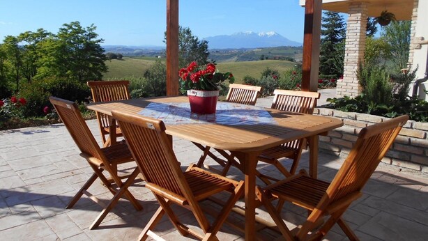 A wooden table and chairs set outdoors with a view of a mountain range. - I Tre Laghi Sant' Agnese - Rustic with pool, aircon (Pescara)