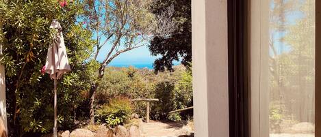 A patio with a pergola, outdoor umbrella, and a view of the sea.