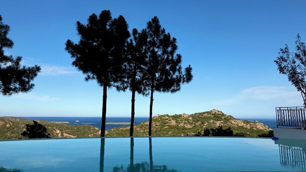 An infinity pool with a clear view of the ocean and hills. - Résidence Pietra Di Sole (Porto-Vecchio)