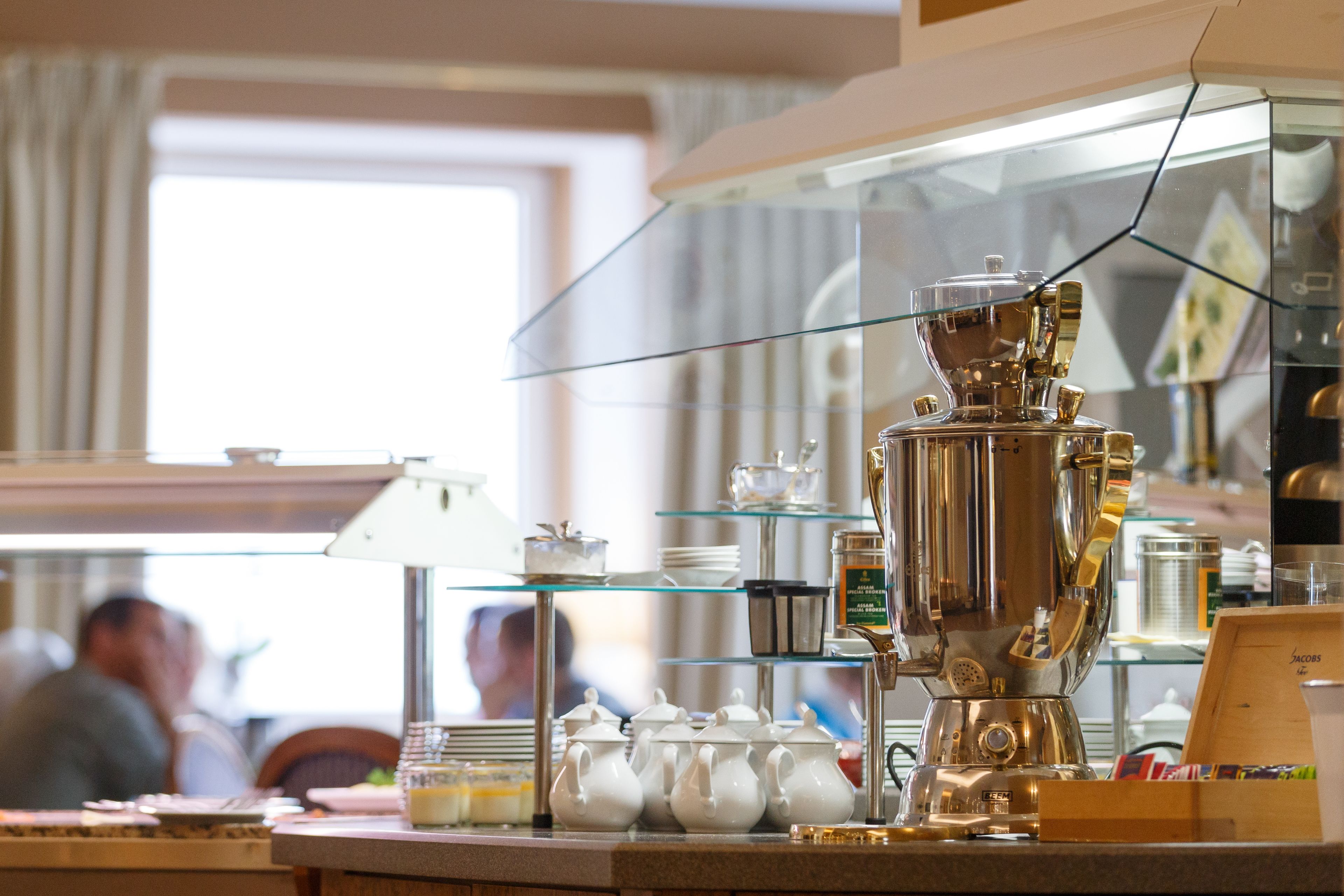 A coffee machine and teapots on a counter in a cafe.