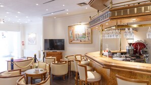 A hotel lobby with a bar area, seating arrangement, and a television. - Hotel Erbprinz (Ludwigslust)