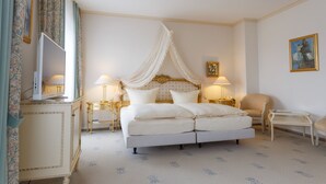 A four-poster bed with a canopy, bedside lamps, a television, and a chair. - Hotel Erbprinz (Ludwigslust)