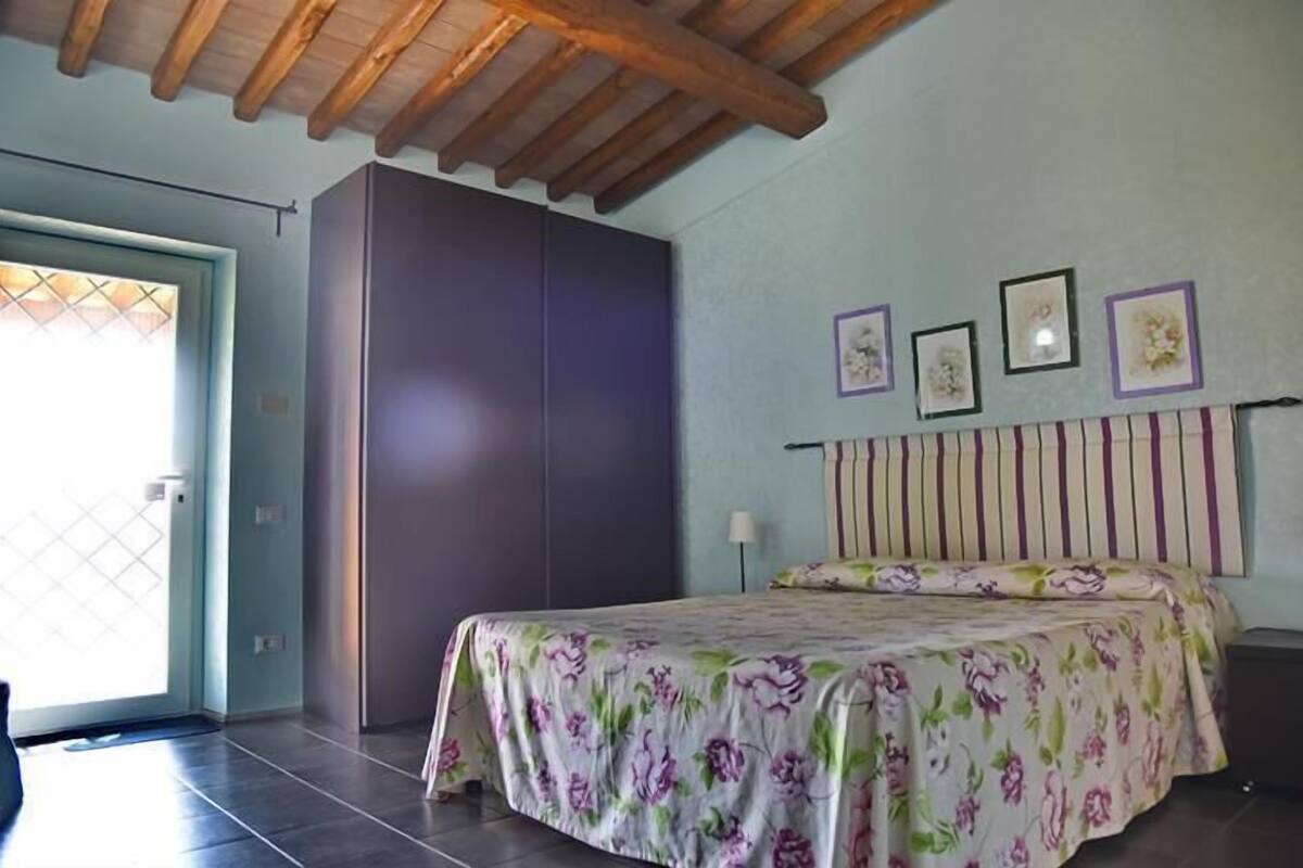 A bedroom with a bed, a wardrobe, and a door.