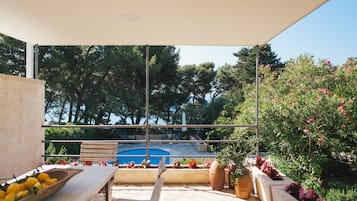 Relax in a serene outdoor space with a clear view of the pool and lush greenery.