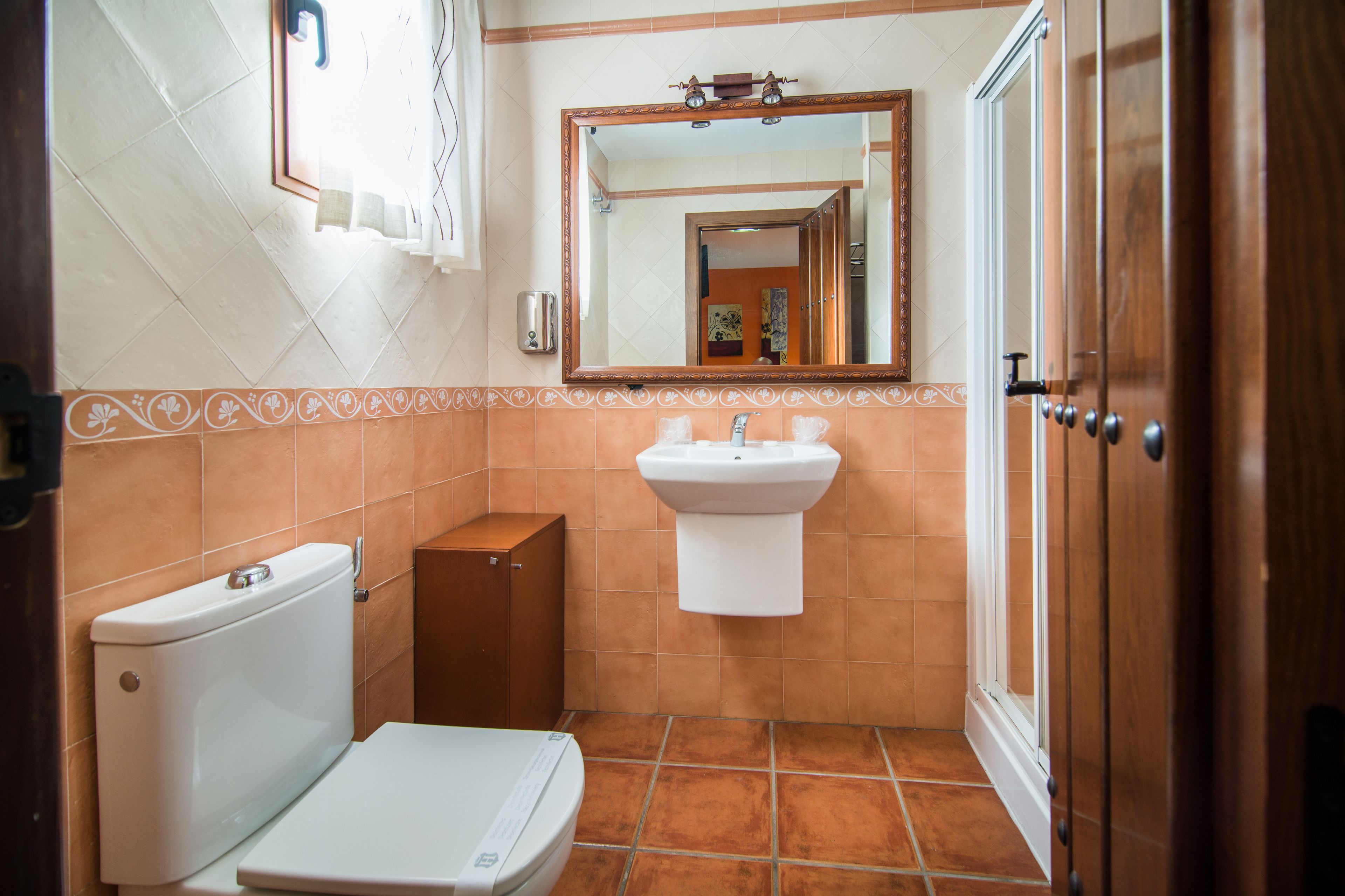 A small bathroom with a toilet, sink, and mirror.
