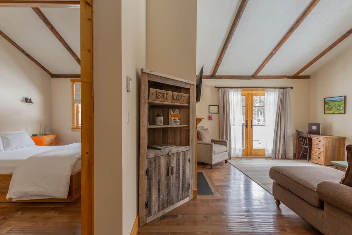 A room with a bed, a wooden cabinet labeled "Ski Loft," a desk, and a chair.