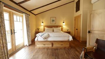 A bedroom with a wooden bed, two nightstands, a bench, and a wardrobe.