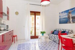 Ein modernes Wohnzimmer mit einer Couch, einem Esstisch und einer Küchenzeile.