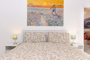 Ein Schlafzimmer mit einem Bett, zwei Nachttischen und einem Wandbild.
