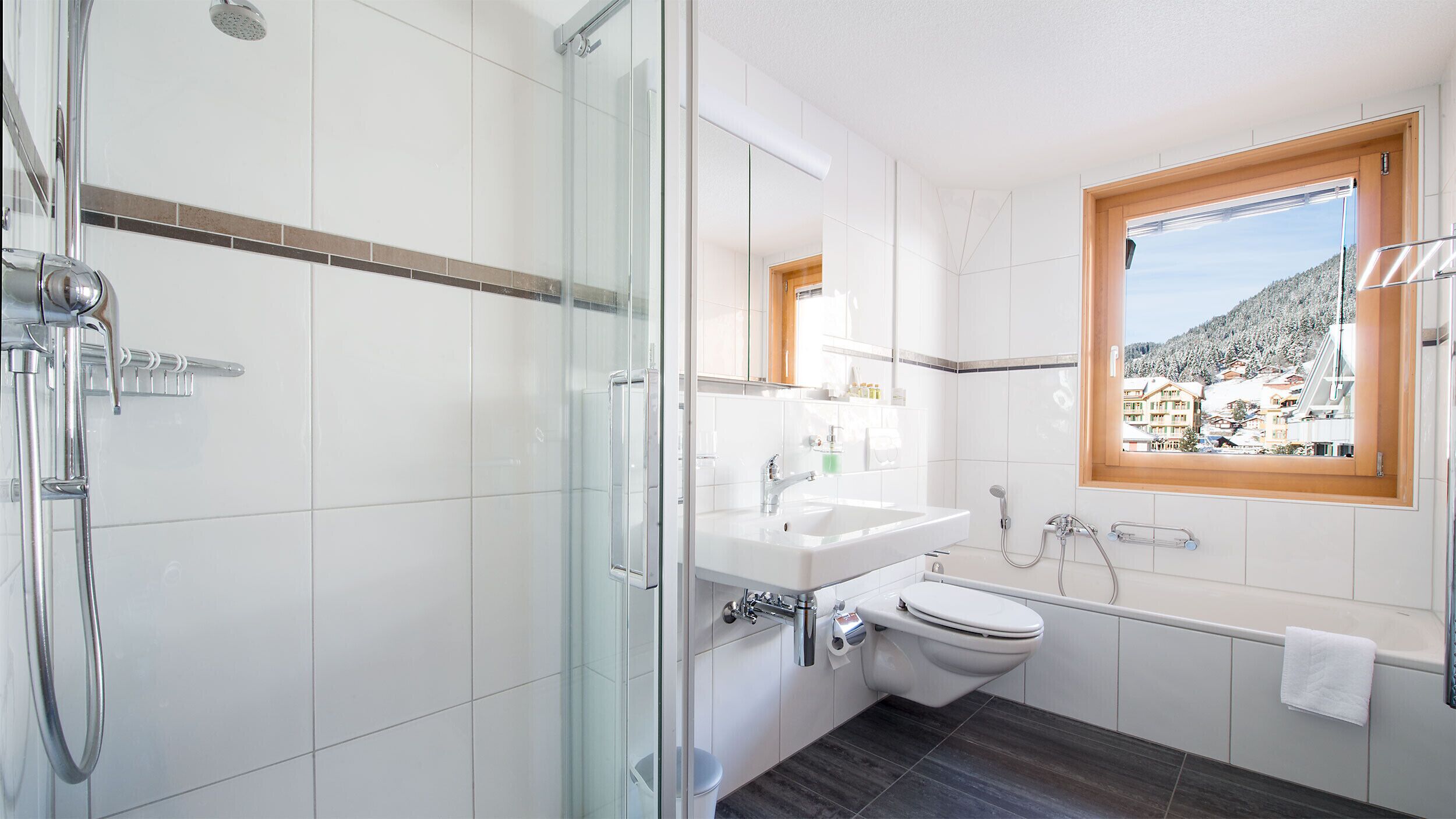 A modern bathroom with a glass shower enclosure, a white sink, a toilet, and a bathtub.