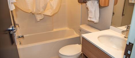 A bathroom with a bathtub, toilet, and sink.