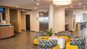 A modern lobby with a reception desk, seating area, and an elevator. - Microtel Inn & Suites by Wyndham Carlisle (Carlisle)