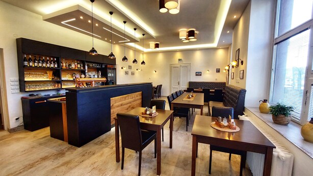 A modern bar area with a counter, seating, and a view of the outside.