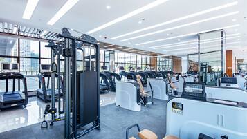 Ein modernes Fitnessstudio mit Laufbändern, Crosstrainern und Gewichten.
