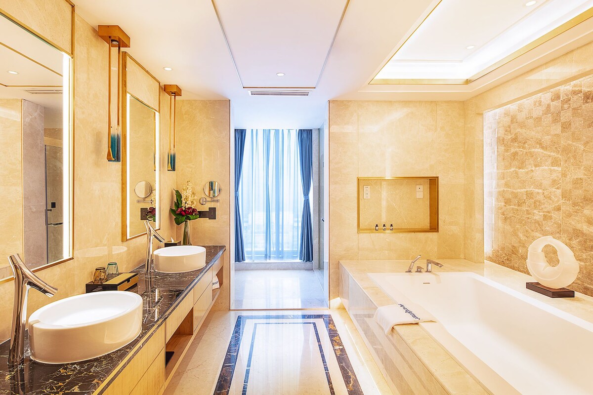 Ein modernes Badezimmer mit zwei Waschbecken, einer großen Badewanne und einem Spiegel.