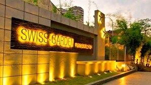 Une enseigne bien éclairée pour la « RÉSIDENCE SWISS-GARDEN », au design moderne, avec des lettres illuminées.