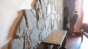 Un muro de piedra con un banco de madera en una habitación.
