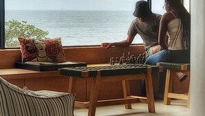A room with a large window overlooking the sea, a wooden bench, and a chessboard. - Ocean Vista Boutique Guest House (Umhlanga)