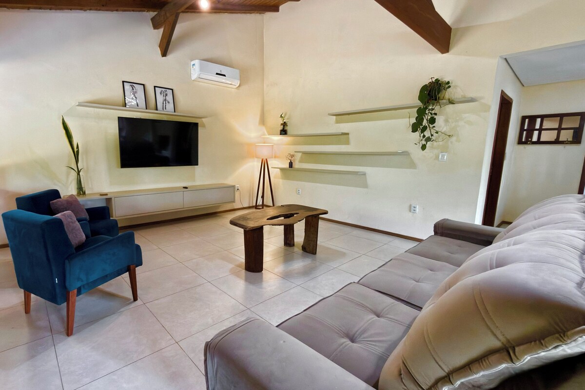 A living room with a TV, sofa, and blue armchair.