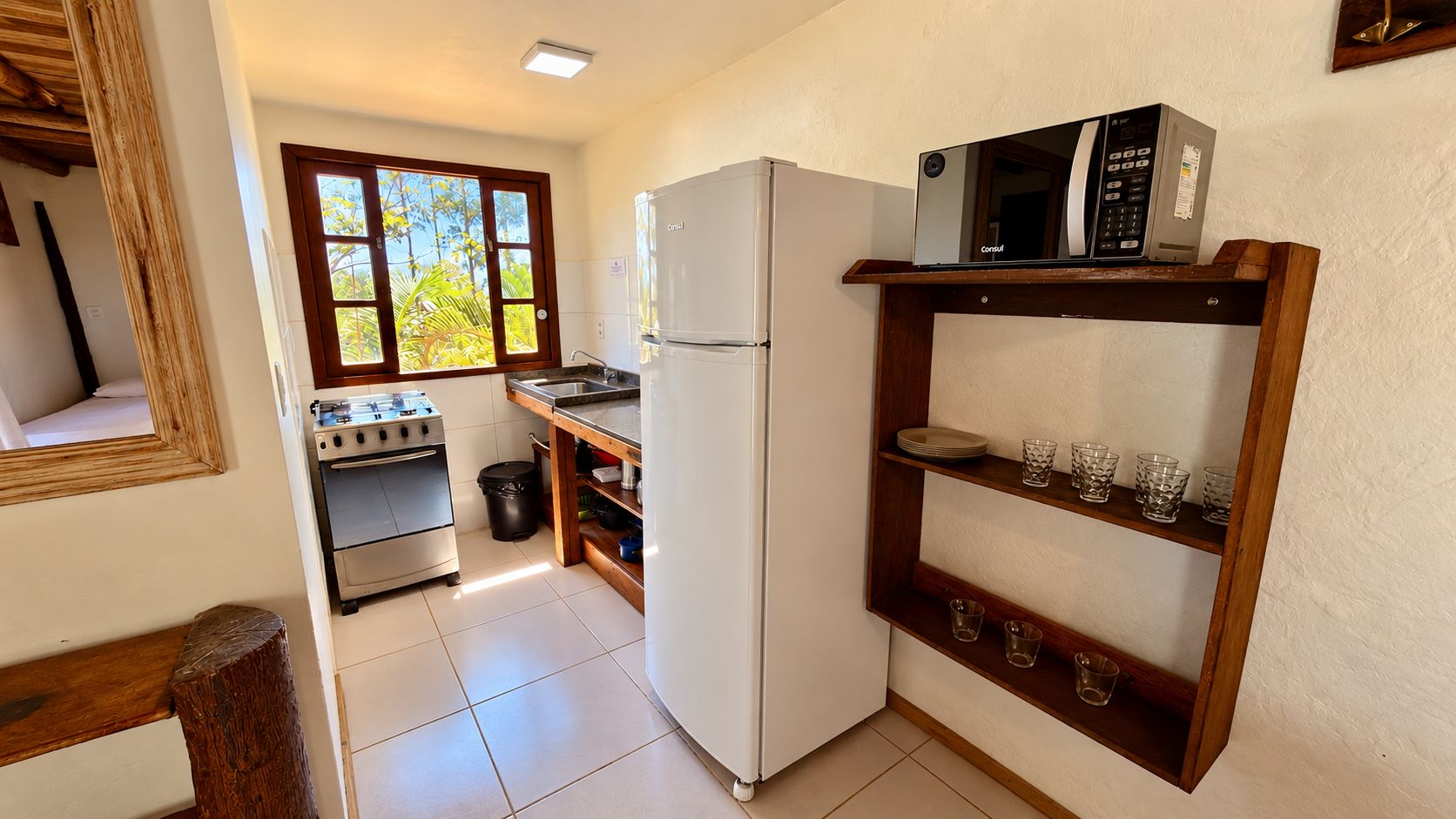 A compact kitchen with a refrigerator, stove, and microwave.