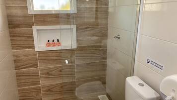 A bathroom with a shower, toilet, and sink.