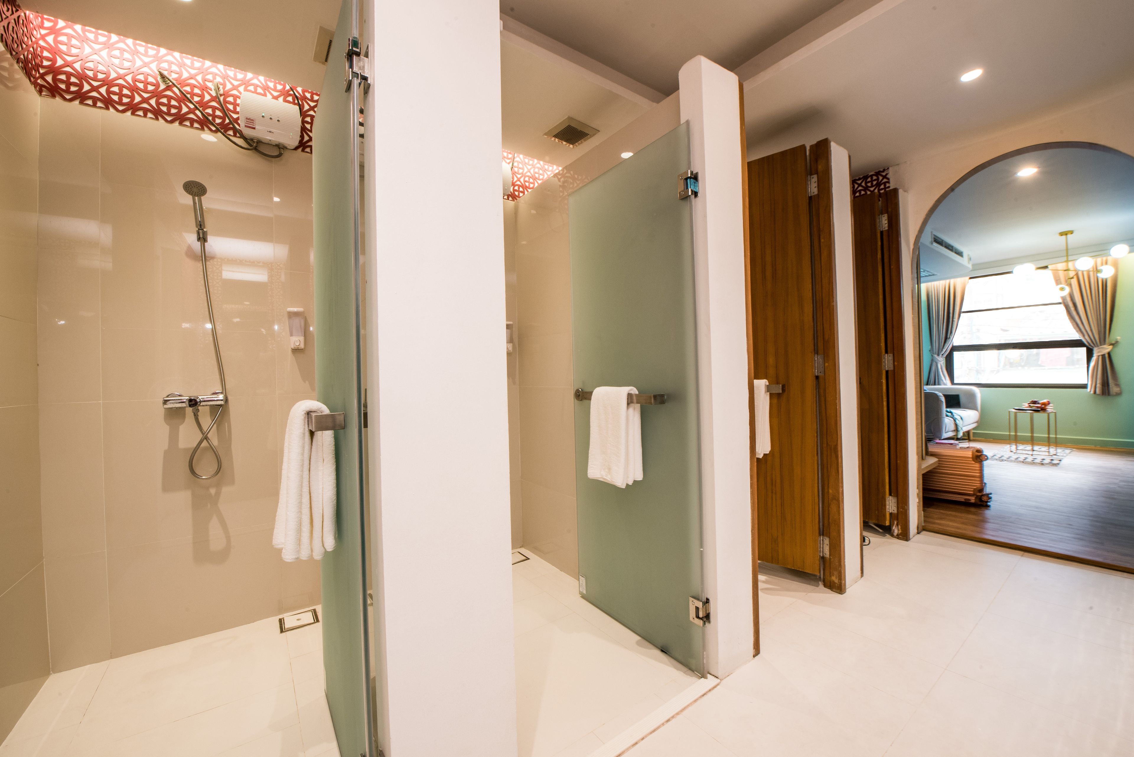 A modern bathroom with a glass shower enclosure, a towel rack, and a visible towel.