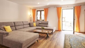 A modern living room with a sectional sofa, a coffee table, and a patterned rug. - Apartment Jenner, 1-4 persons, 135 sqm, 1 bedroom, terrace, near Königssee (Schönau am Königssee)
