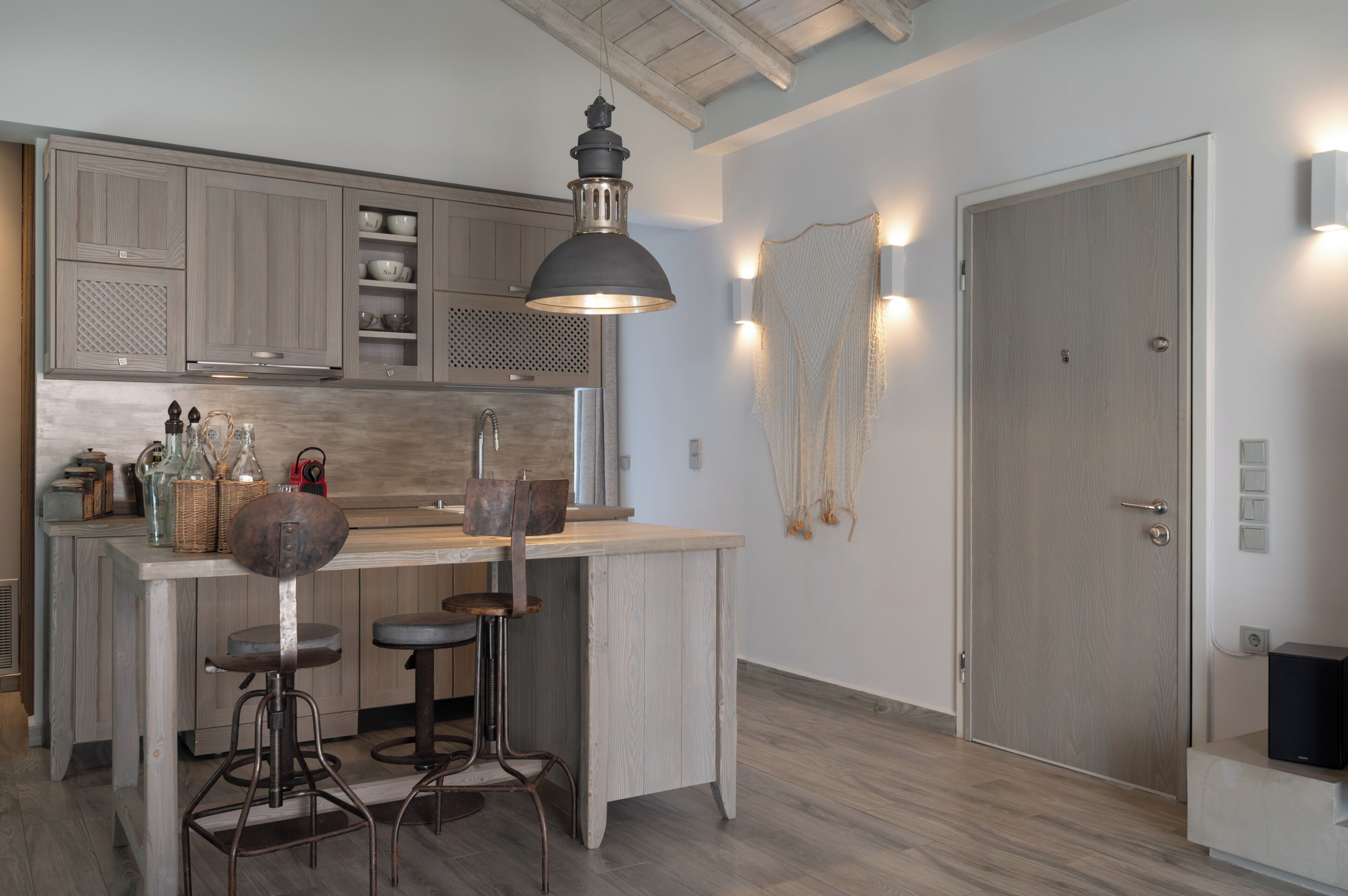 A kitchen with a bar area, wooden cabinets, and a hanging light fixture.