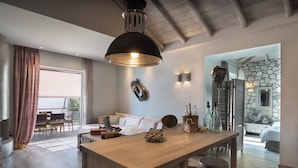 Un amplio salón con una isla de madera, una lámpara colgante grande y una pared de piedra.