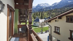 Un balcon doté d’une balustrade en bois, d’où l’on peut admirer un paysage montagneux.