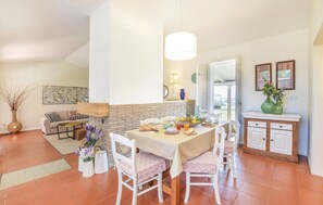 Cozy dining area with a table for four, surrounded by comfortable seating and artwork.